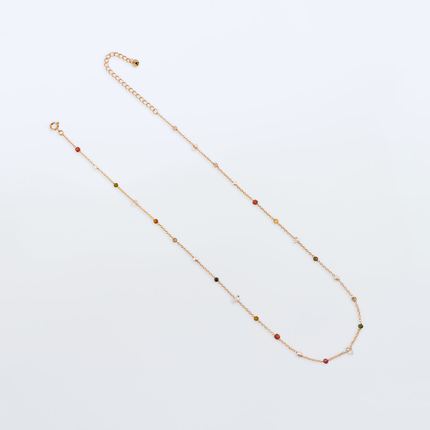 Lenora high quality natural multi-colored gemstone beaded chain adjustable necklace 14K gold filled, top view with plain white background. Featuring high quality AAA Herkimer Diamond Quartz, Garnet, Rainbow Tourmaline, Natural Freshwater Rice Pearls and Smokey Quartz gemstones.