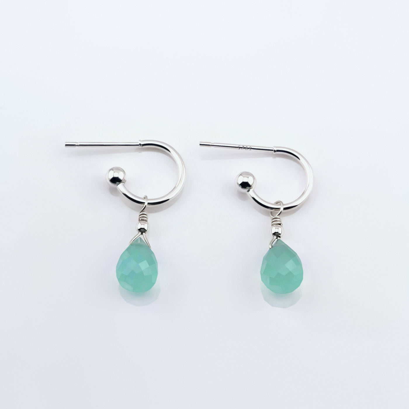 Pair of sterling silver interchangeable mini hoop earrings, with blue-green teal AAA quality aqua chalcedony teardrop shaped briolette gemstones  on a plain white background, top view.
