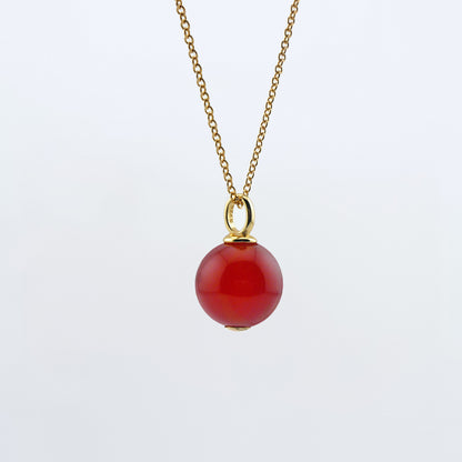 Front view of a dainty round red carnelian ball sphere pendant necklace in 14k gold plated 925 sterling silver on a 14k gold filled chain hanging, with a plain white background.  