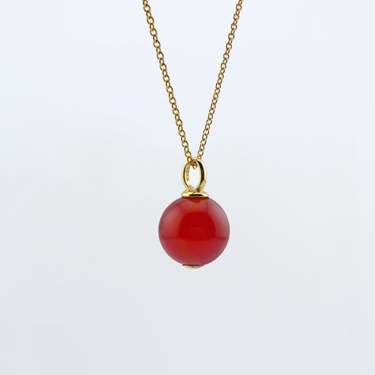 Front view of a dainty round red carnelian ball sphere pendant necklace in 14k gold plated 925 sterling silver on a 14k gold filled chain hanging, with a plain white background.  