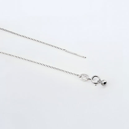 Dainty adjustable sterling silver chain necklace. It shows the ends of the adjustable pin, ball and clasp laying flat on a plain white background.