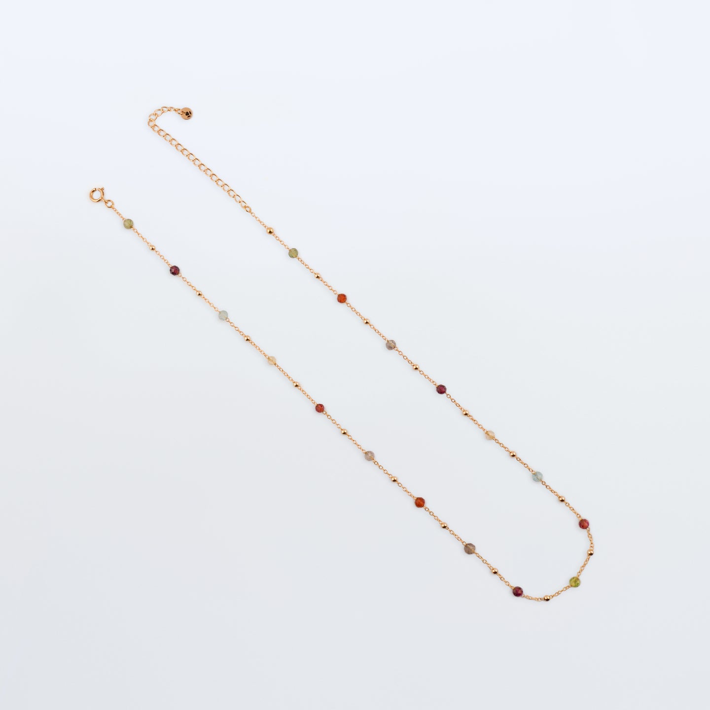 Estelle dainty high quality natural multi-colored gemstone beaded chain adjustable necklace 14K gold filled, top view with plain background. Featuring high quality AAA Apatite, Agate, Citrine, Garnet, Labradorite, Obsidian, Peridot gemstones.