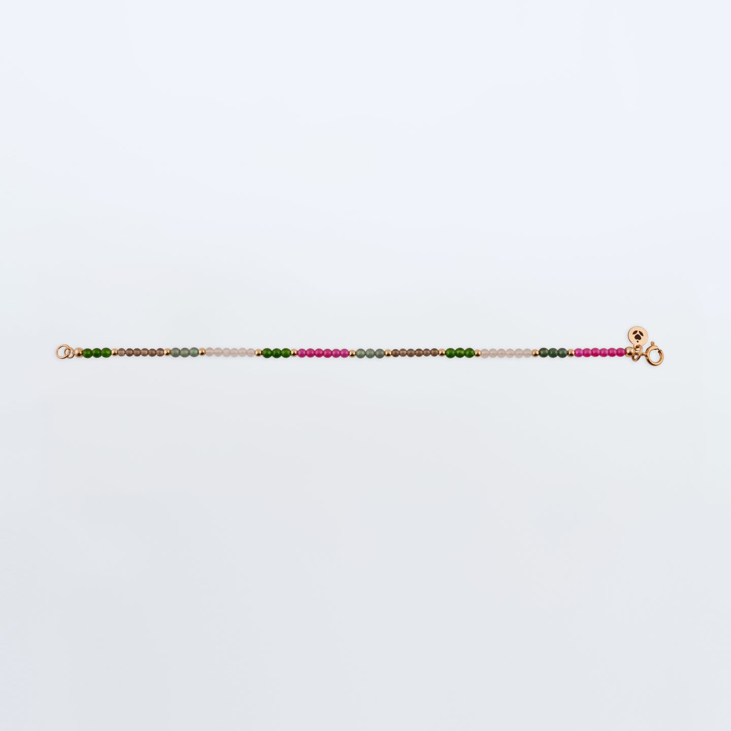 Multicolored gemstone beaded bracelet with Ruby pink beads, Guatemalan Jade, Taiwan Jade green beads, Smokey Quartz light brown beads, Rose Quartz light pink beads on a plain white background. 