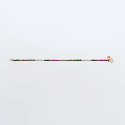 Multicolored gemstone beaded bracelet with Ruby pink beads, Guatemalan Jade, Taiwan Jade green beads, Smokey Quartz light brown beads, Rose Quartz light pink beads on a plain white background. 