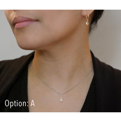 Close-up of a person wearing a dainty high quality AAA Herkimer Diamond Quartz wire wrapped pendant chain necklace and matching Herkimer earring hoops in sterling silver. The person has on a black top and sweater.